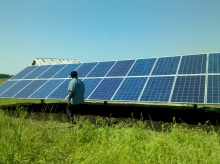 man in front of ground mounted solar panels