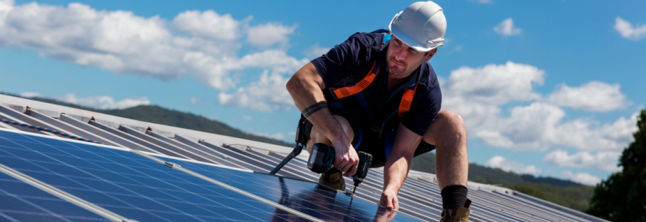 Solar Worker Working on Rooftop Solar Panel