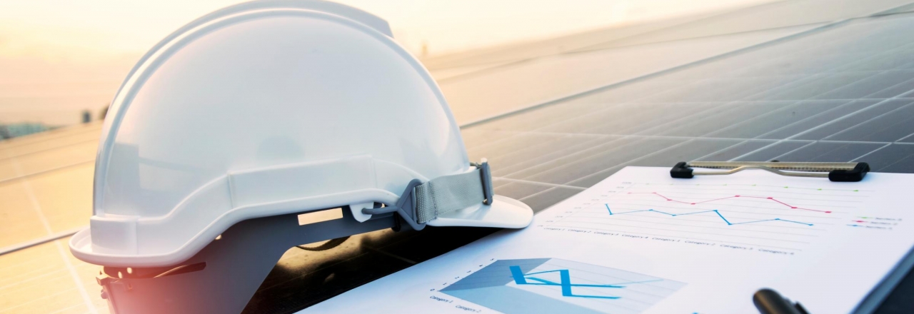 Commercial Work Helmet on a Solar panel with clipboard