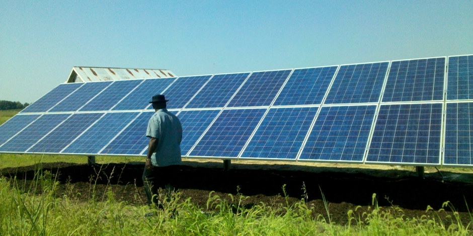 man in front of ground mounted solar panels